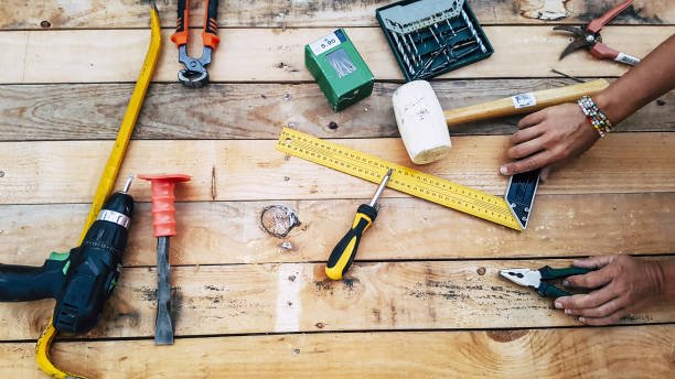 Above view of mixed hardware stuffs on a wood table maded by recycled pallets. do it yourself repair and contruct furnitures like hobby concept. woman hand at work